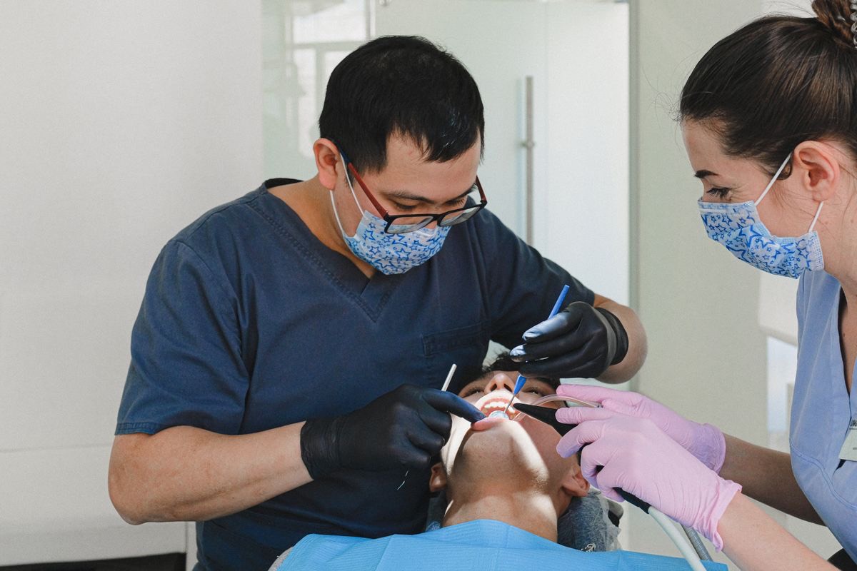 Dental professionals performing periodontal cleaning treatment